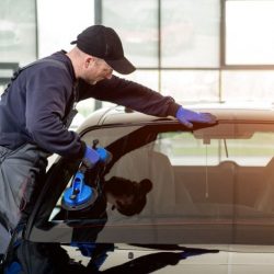 Premium Photo _ Automobile special workers replacing windscreen of a car in auto service